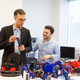 Dalloro holding a plastic object built by the bots.